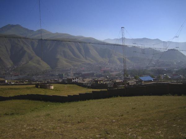 The confluence is near the wall, in the left third of the frame.