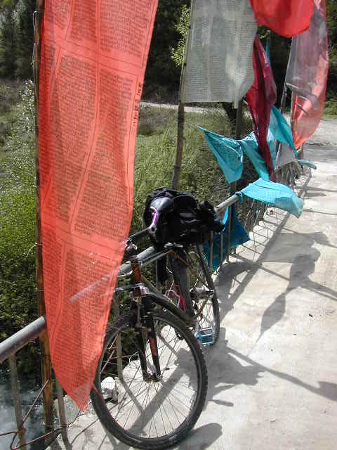My bike and Tibetan Prayer Flags at a bridge