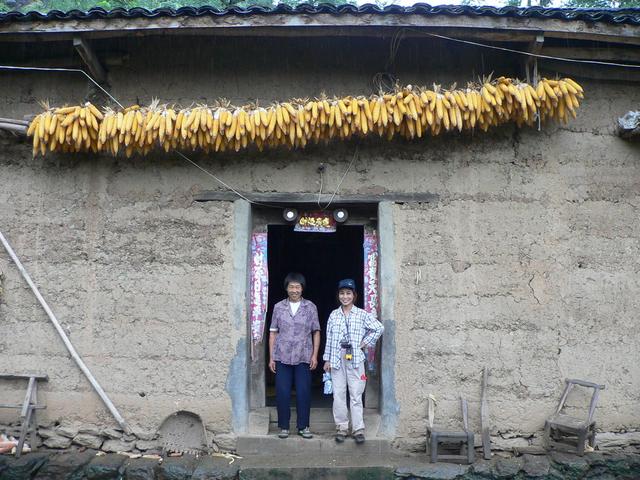 Ah Feng and nice lady in doorway of her home.