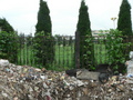 #10: Another view from a mound of rotting garbage piled against the front fence; the confluence likely on or near the cement road just visible in the centre of the photo