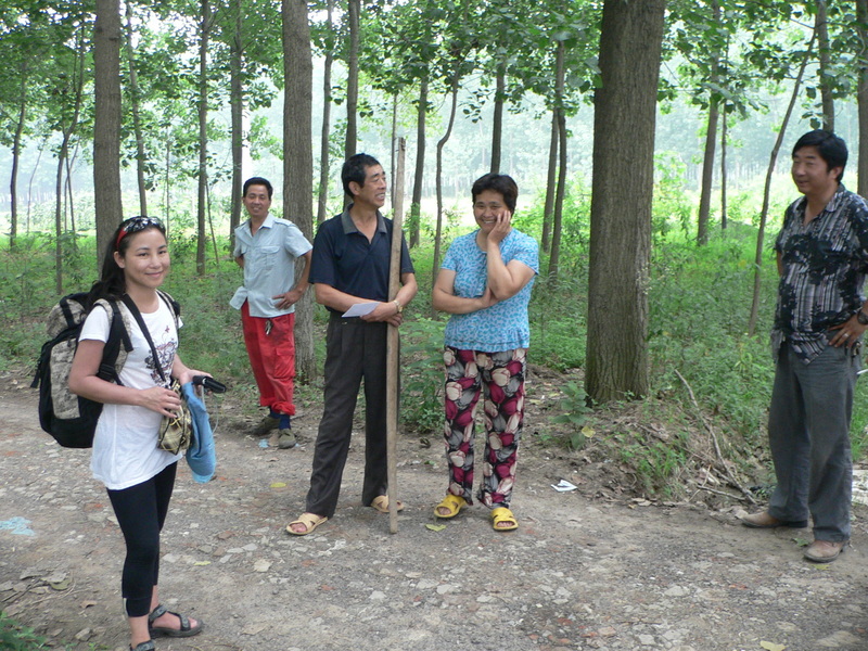 Ah Feng with interested onlookers; Liú Xùmíng in the centre, holding the shoulder pole