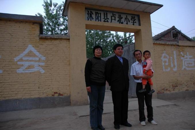 Principle and Mrs Zhou and thier son in law in front of the school
