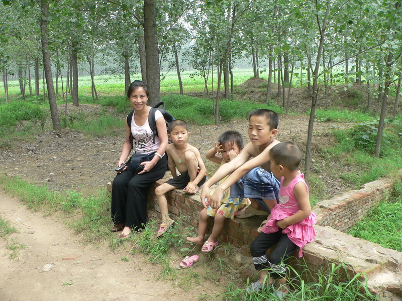 Ah Feng with some children relaxing on a small bridge