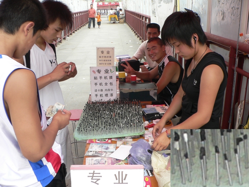 Girl selling styluses on a pedestrian overpass in Púyáng City