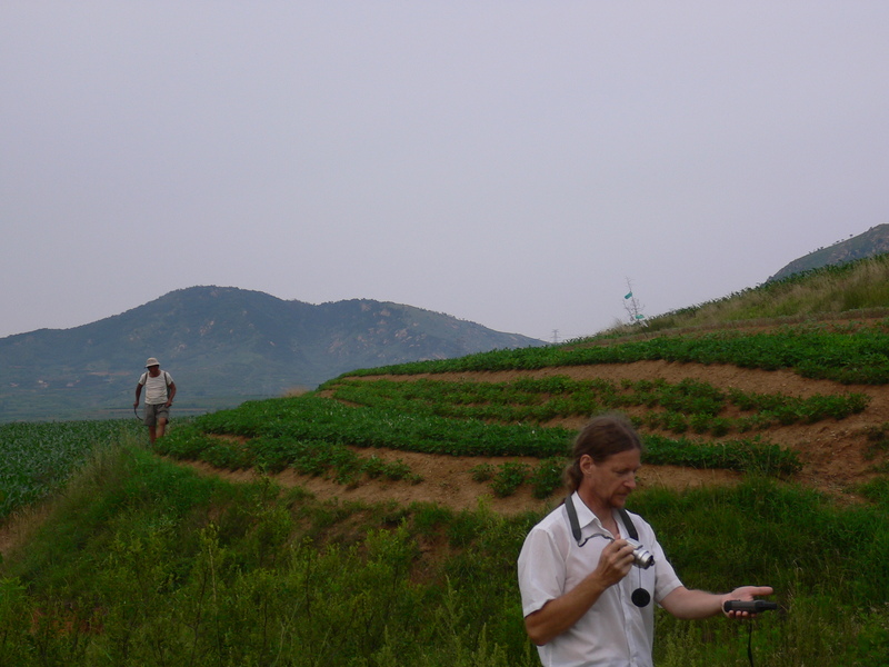 Targ taking the confluence photos while a farmer sprays bug killer in a field of peanuts in the background