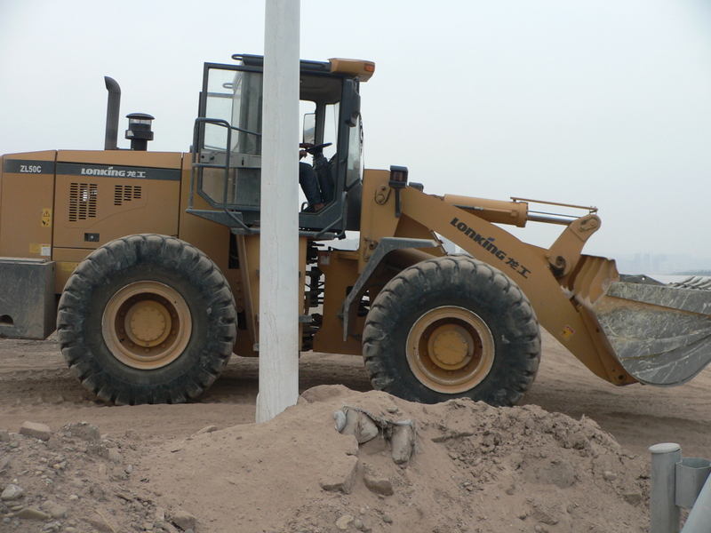 Bulldozer on dirt track near confluence