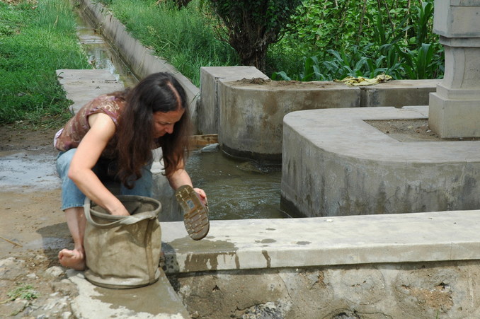 Florence trying to srub off the mud from her shoes