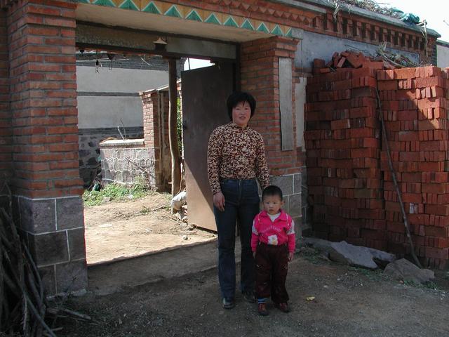 Mrs He and her daughtor in front of thier home - CP 10 meters behind them