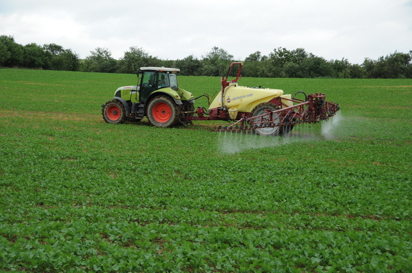 A tractor spraying chemical right on the confleunce point