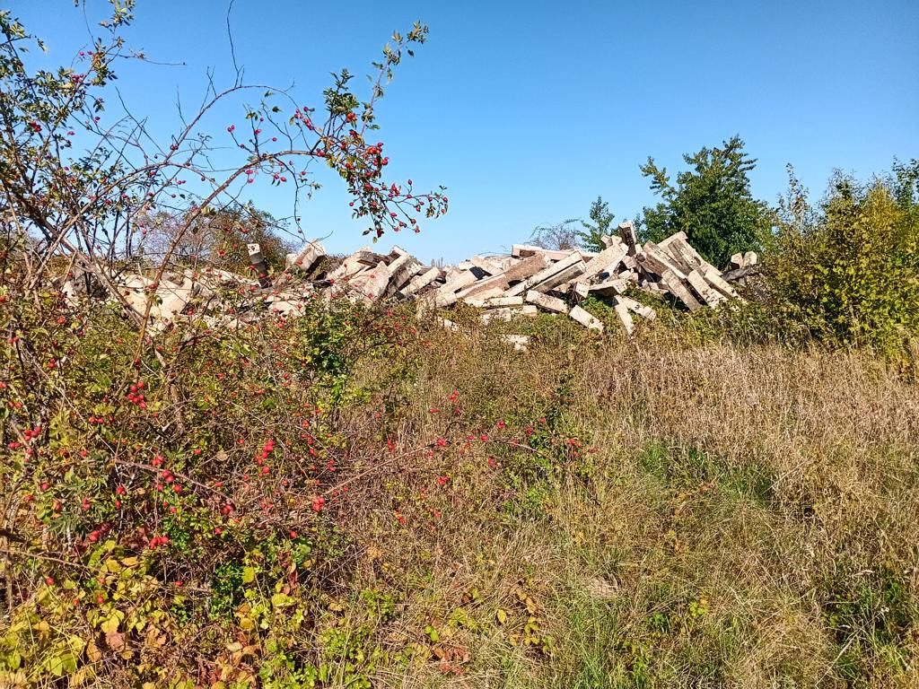 barrier of railway sleepers; from field towards parking