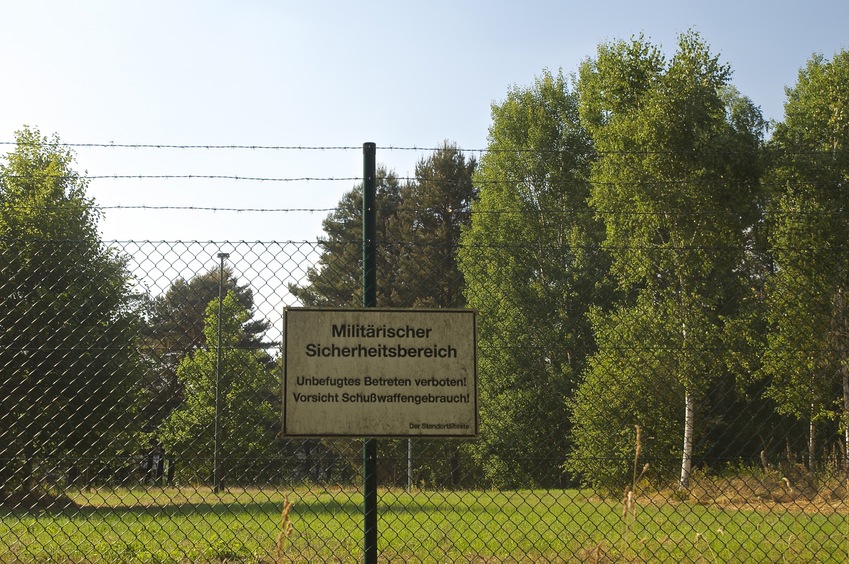 A warning sign at the nearby military base: "Military Security. Trespassing Prohibited. Caution, Firearms!"