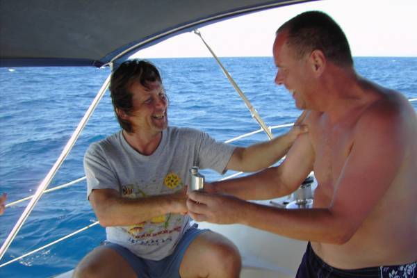 The 1st mate congrats the skipper with a shot of rum