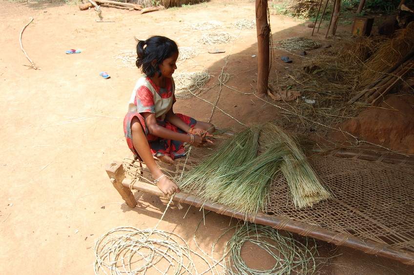 Little hands rolling out the grass strands into ropes