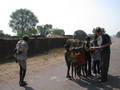 #5: The group of children and men bailing hay in the background at the village we stopped at.