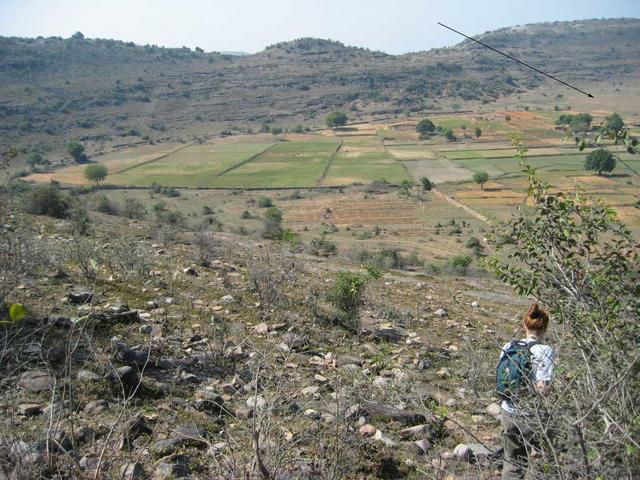 View of the confluence, from the top of the hill.  The arrow points to the general spot, at the base of the farthest hill.