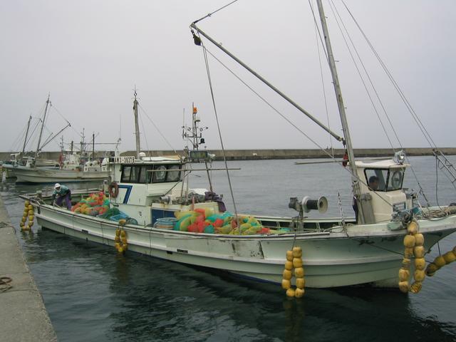 Woman in back, man driving our 'confluence boat'.  Note the fluorescent scallop bags.