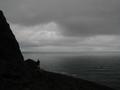 #3: Gjertrud standing on the edge below the confluence. Atlantic ocean to the West and Einevarden to the East,