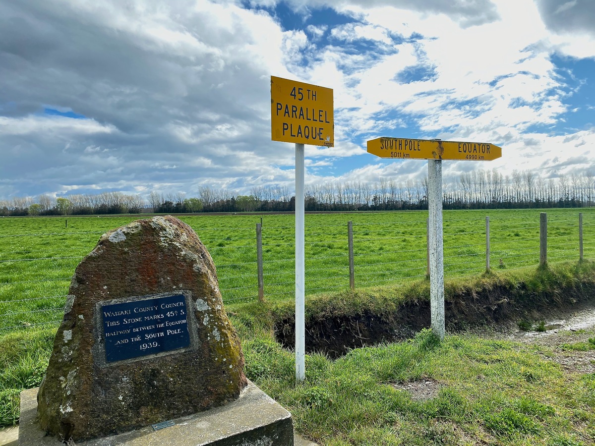 A plaque and sign marking 45 Degrees South, on nearby State Highway 1