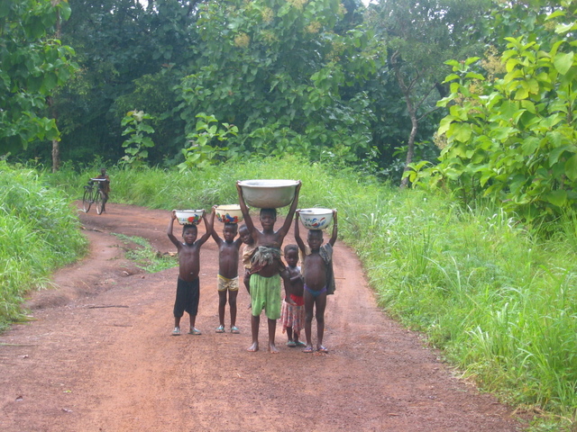 Girl carrying 20 litres of water and her brother