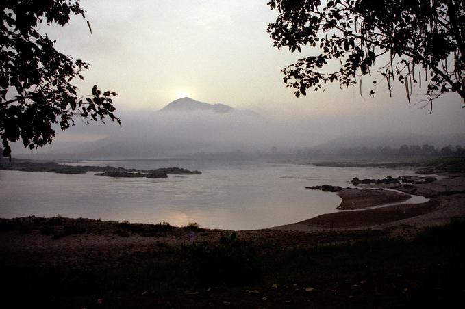 Sun rising over moutain; Mekong rapids in foreground