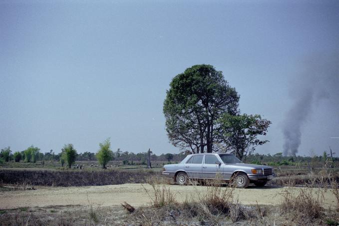 Parking spot in fields; smoke from buring field in distance