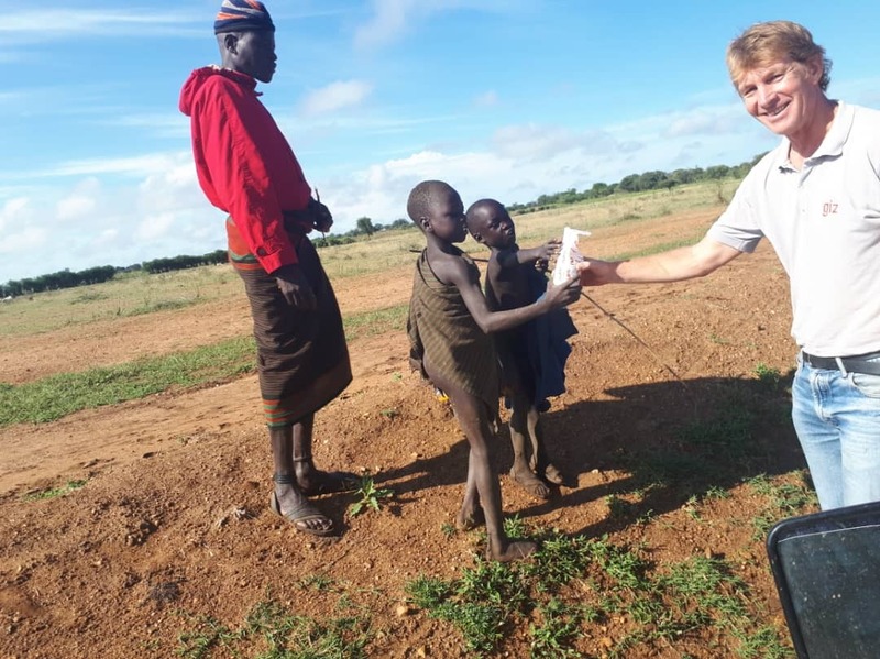 Handing over biscuits to the Karamojan people