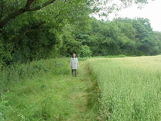 Jane in the wheat field with the confluence just behind her.