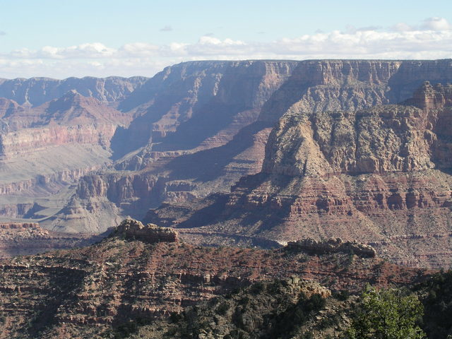 Remnants of Coconino Sandstone resemble two ships in a line.  Barely visible on the horizon is the famous Grand Canyon Desert View Watchtower.