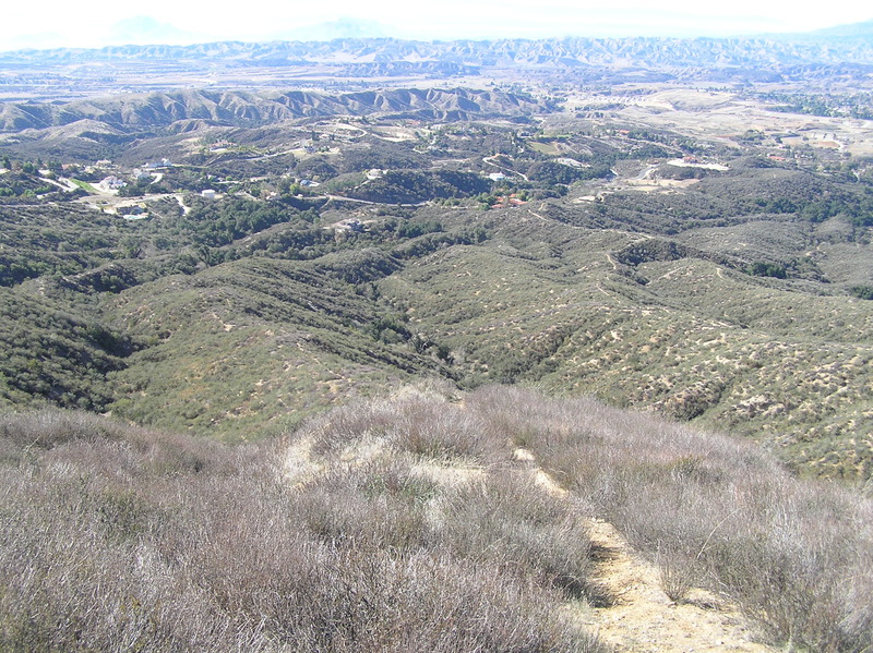 From the ridgetop to the east:  Looking west, the confluence lies in the valley in the mid-center of this photograph.