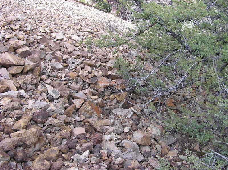 The confluence point lies on the edge of a scree slope, on a steep hillside