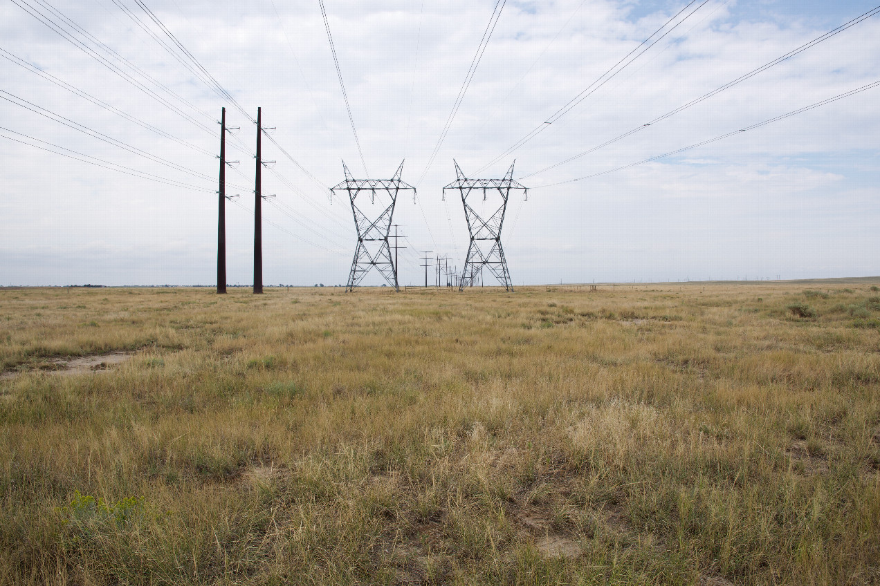 The confluence point lies in grassland, under high-voltage power lines.  (This is also a view to the North.)