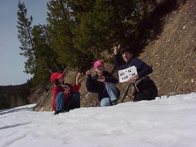 Confluence visitors in the snow pointing the way to 40 N 106 W.