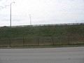 #3: View south across the frontage road to the freeway beyond the embankment.