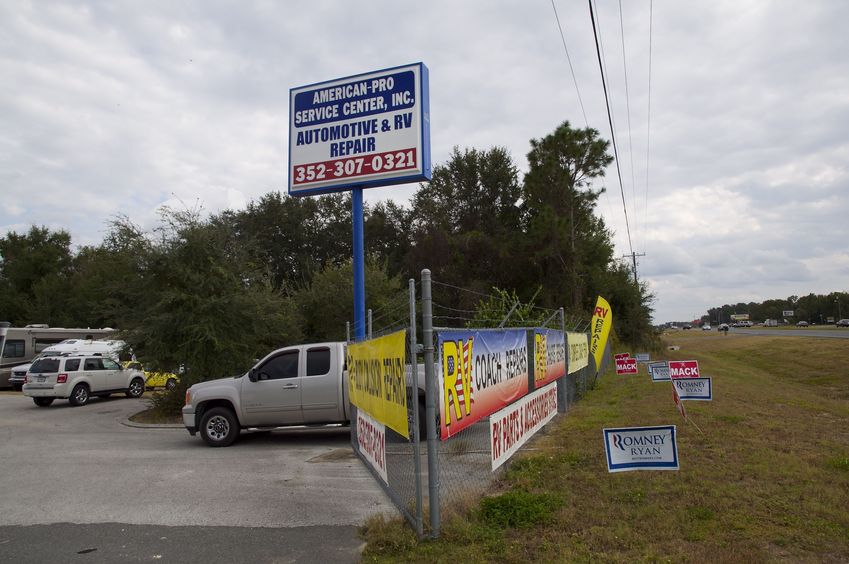 A front-on view of the RV repair shop (with the confluence point at the left).  Just days from the 2012 presidential election, there are lots of Mitt Romney supporters in this part of Florida.