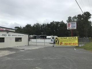 #1: The confluence of 29 North 82 West, in the mid-distance, behind the reverse facing white sign and behind the fence, looking northeast. 