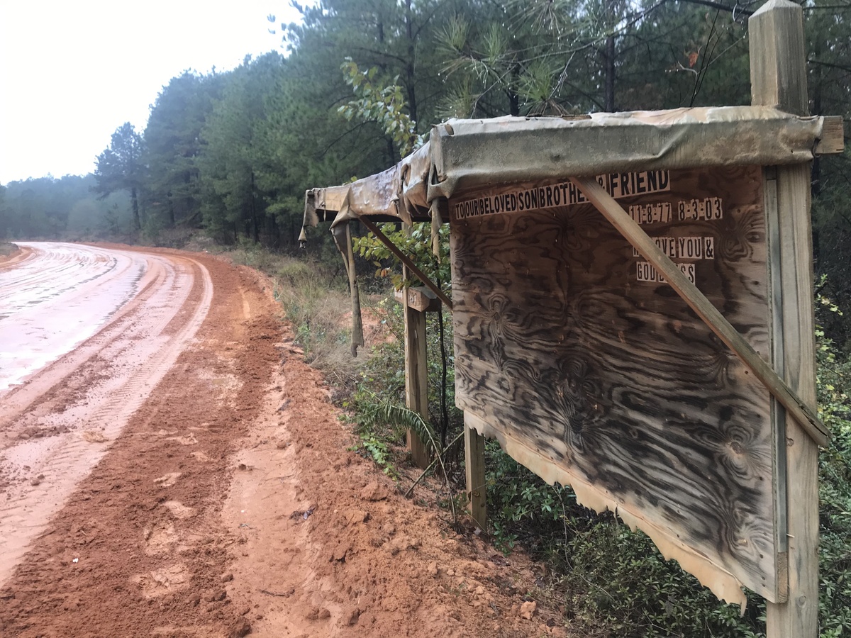 Roadside memorial and muddy road en route to the confluence point. 