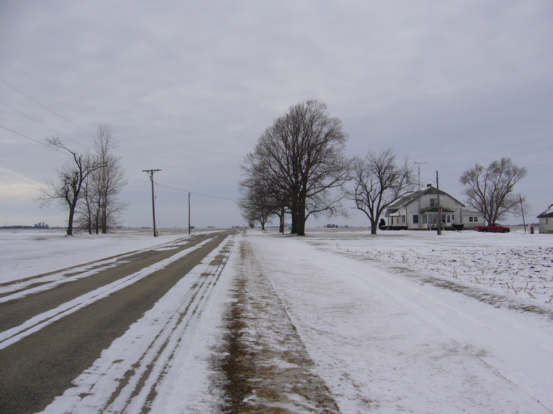 West: road, field and house