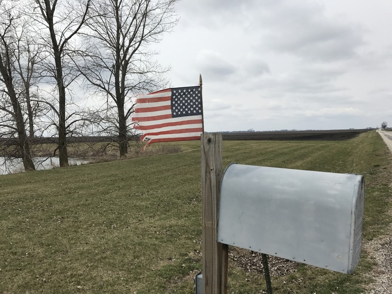 Flag flying in the stiff breeze and mailbox 