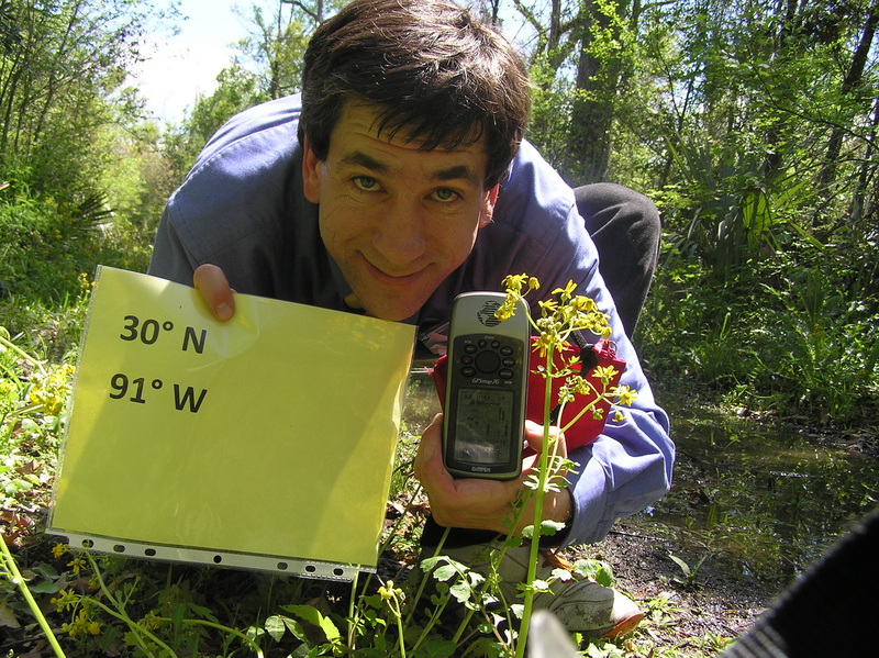 Joseph Kerski crouching in the swamp at the confluence site.