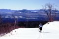 #5: Snowshoeing over the crest of a hill with the Western Mountains in the background