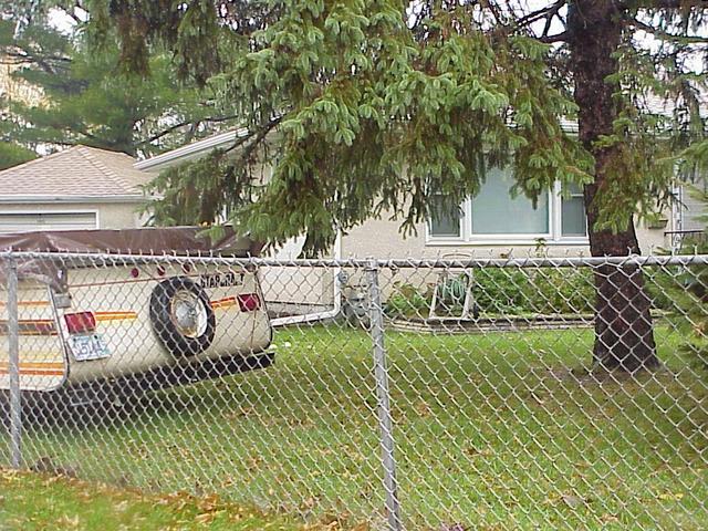 View of the confluence, located between the camper and the tree at 1945 Polaris Place, North St Paul, Minnesota.