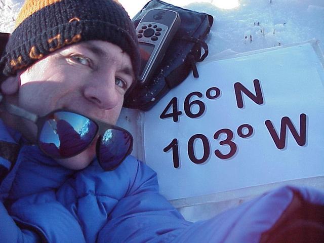 Geographer Joseph Kerski lying in the snow at the confluence site.