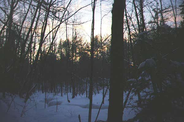 Sun sets in the snow covered valley.