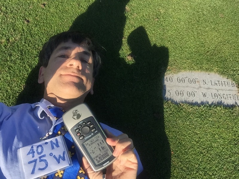 Joseph Kerski lying on the confluence point marker.