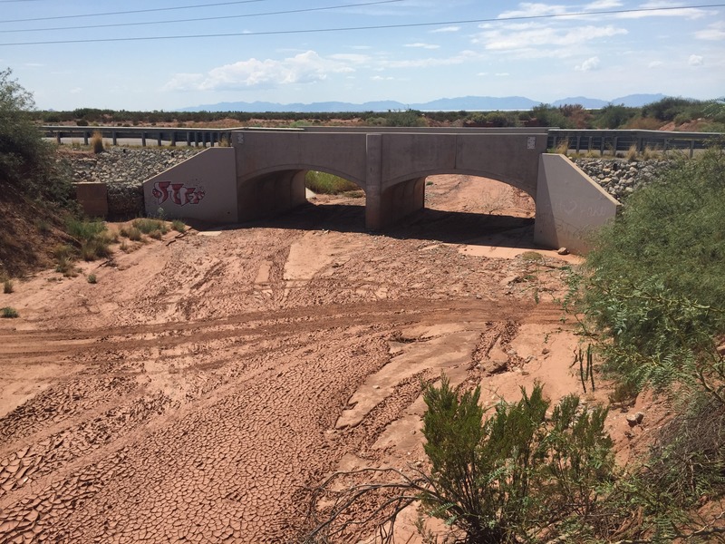 View of the arroyo to the south of the confluence, looking west at the railroad bridge.