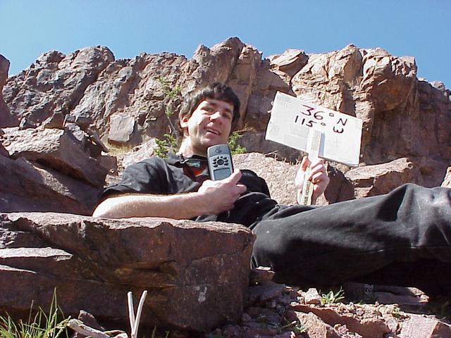 Geographer Joseph Kerski with sign at the confluence.