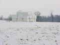 #7: Looking southeast from the confluence at the field and covered hay bales.