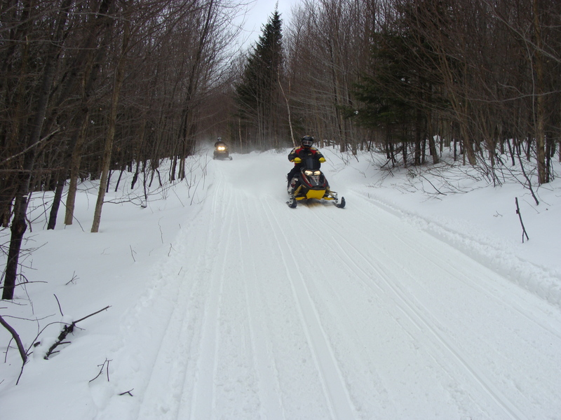 Snowmobilers whiz by with 200 meters of 43N 73W on F.R. 83.