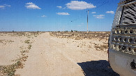 #10: a bumpy hard clay road follows the power lines