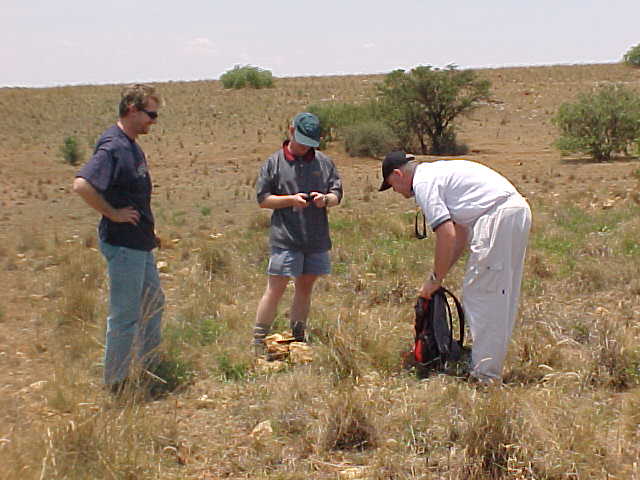 Henning, Roland and Barry use rocks in the area to build a small cairn on the point of 26S 26E